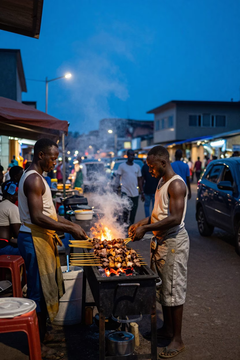 Busy Accra Street Scene at Blue Hour with Grilled Kebab Vendor and Tuk-Tuk in in Accra, Ghana