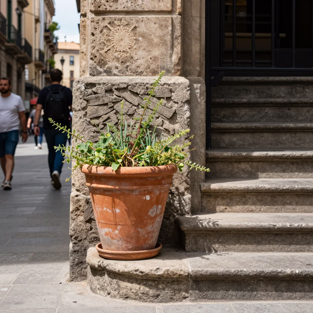 Busy Barcelona street corner with terracotta pot and stair rail in bright midmorning light in in Barcelona, Spain