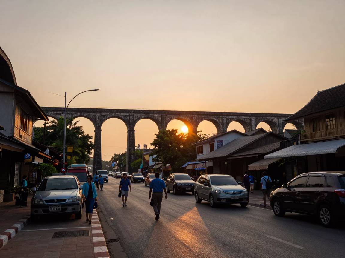 Busy Chiang Mai Street Scene at Sunset with Railway Viaduct and River Activity in in Chiang Mai, Thailand