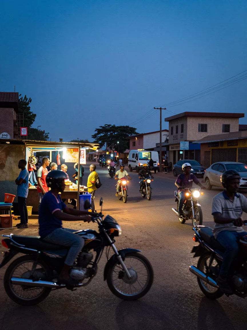 Busy Dakar Street Scene at Indigo Twilight with Motorcycles and Local Commerce in in Dakar, Senegal
