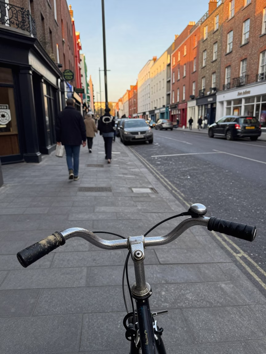 Busy Dublin Street Corner Late Morning 1970s Scene with Vintage Bicycle and Local Shopfronts in in Dublin, Ireland