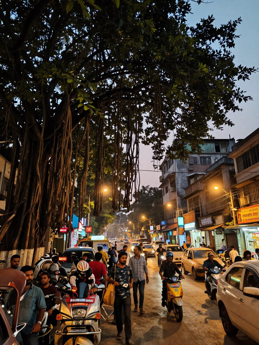 Busy Kolkata Street Scene at Dusk with Banyan Tree and Tea Stall in in Kolkata, India