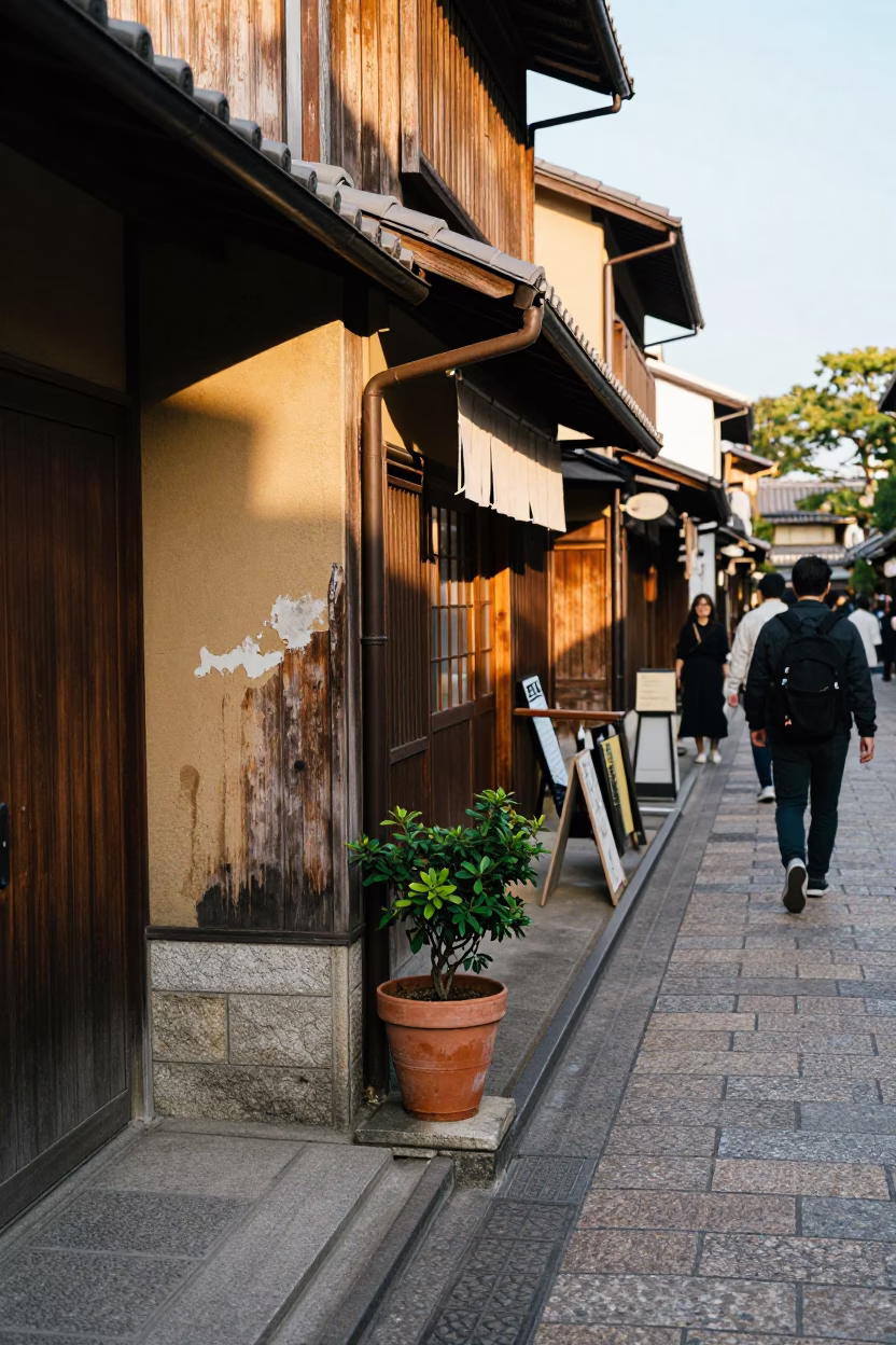 Busy Kyoto Street Scene with Flowerpot and Smudged Wall in Late Afternoon Light in in Kyoto, Japan