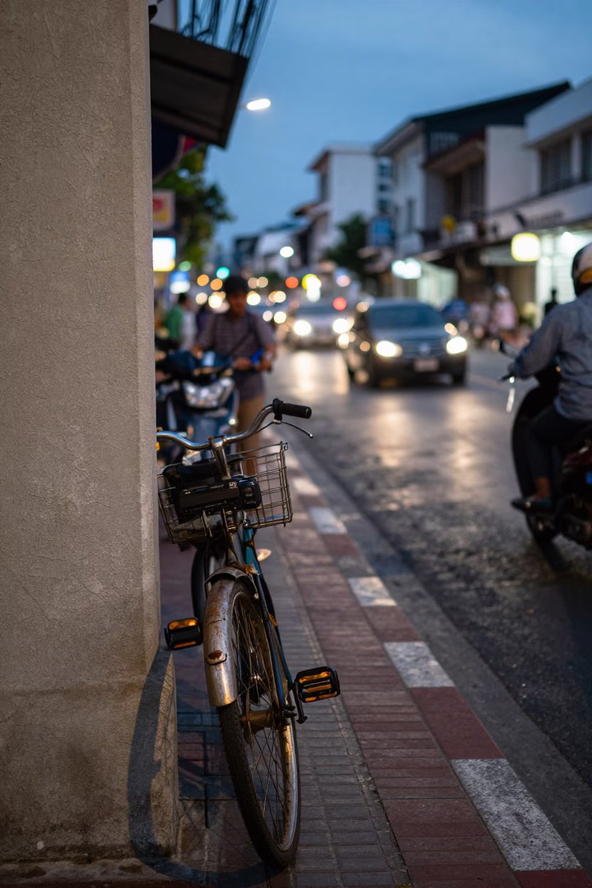 Busy Phuket Street Scene at Dusk with Bicycle and Concrete Wall Shadows in in Phuket, Thailand