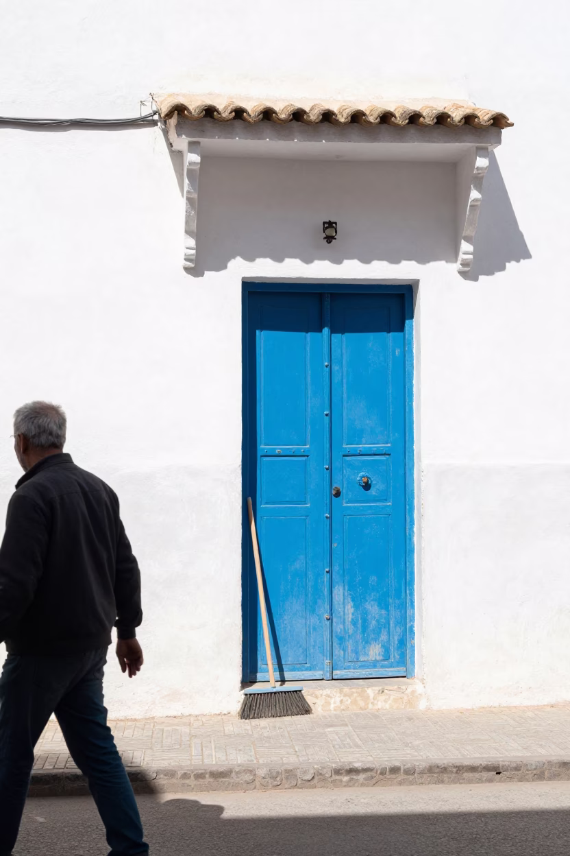 Busy Street Corner in Essaouira Morocco with Blue Door and Hand Broom in in Essaouira, Morocco