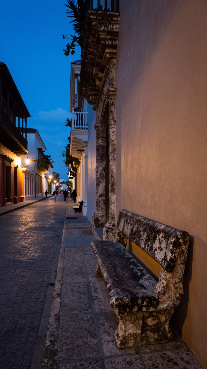 Cartagena Colombia indigo twilight street scene with stone bench and local pedestrians in in Cartagena, Colombia