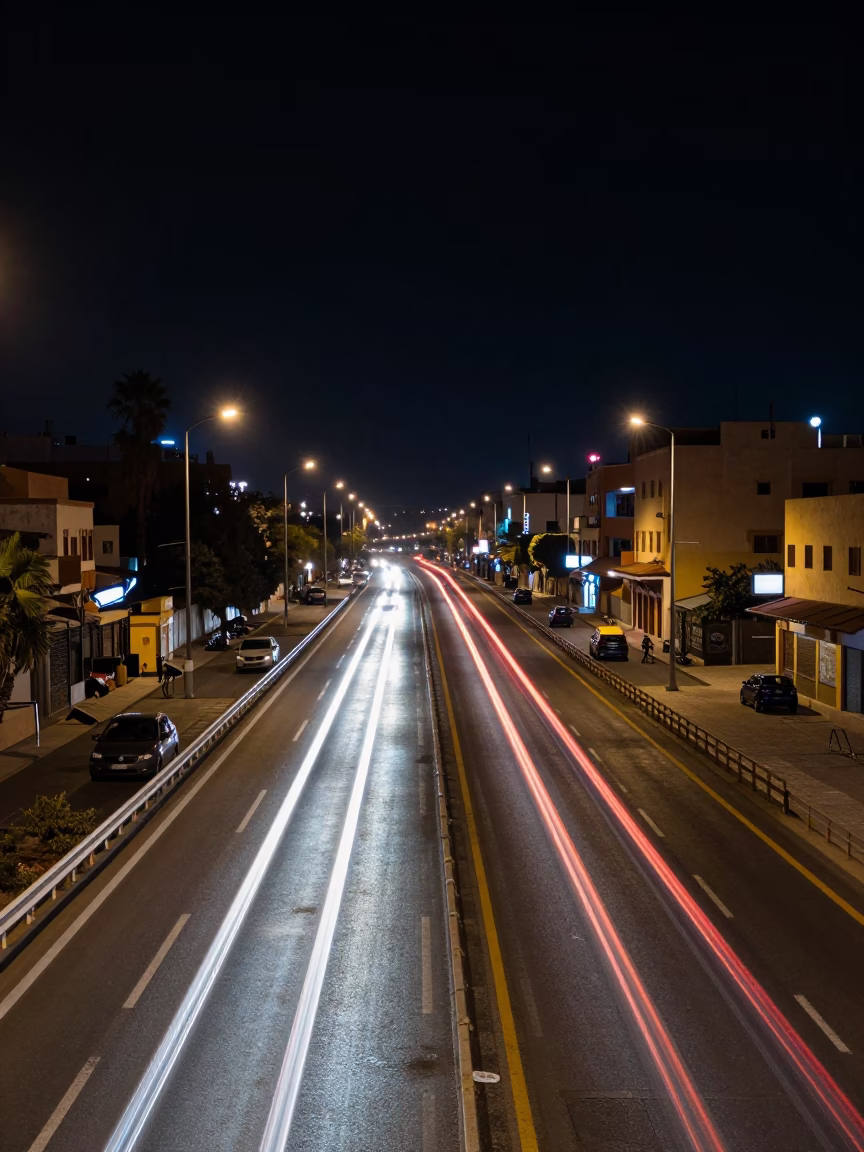 Casablanca Night Street Scene with Car Headlight Trails and Local Vendor at Deep Night in in Casablanca, Morocco