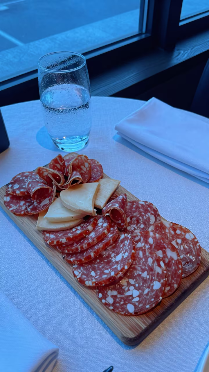 Charcuterie and Sparkling Water on Linen Table in on a linen-covered restaurant table in Harbin