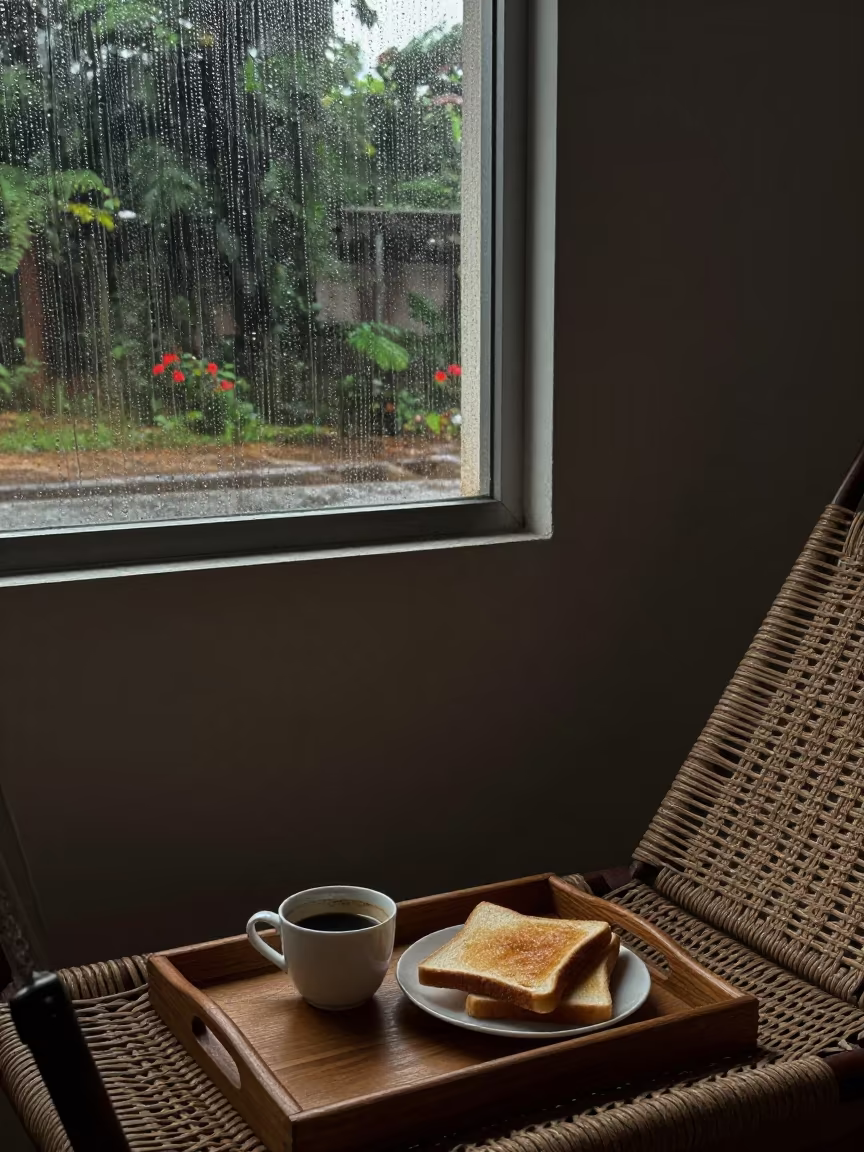 Coffee and Toast on Porch Swing in Rain in beside a rain-streaked window in Brazzaville