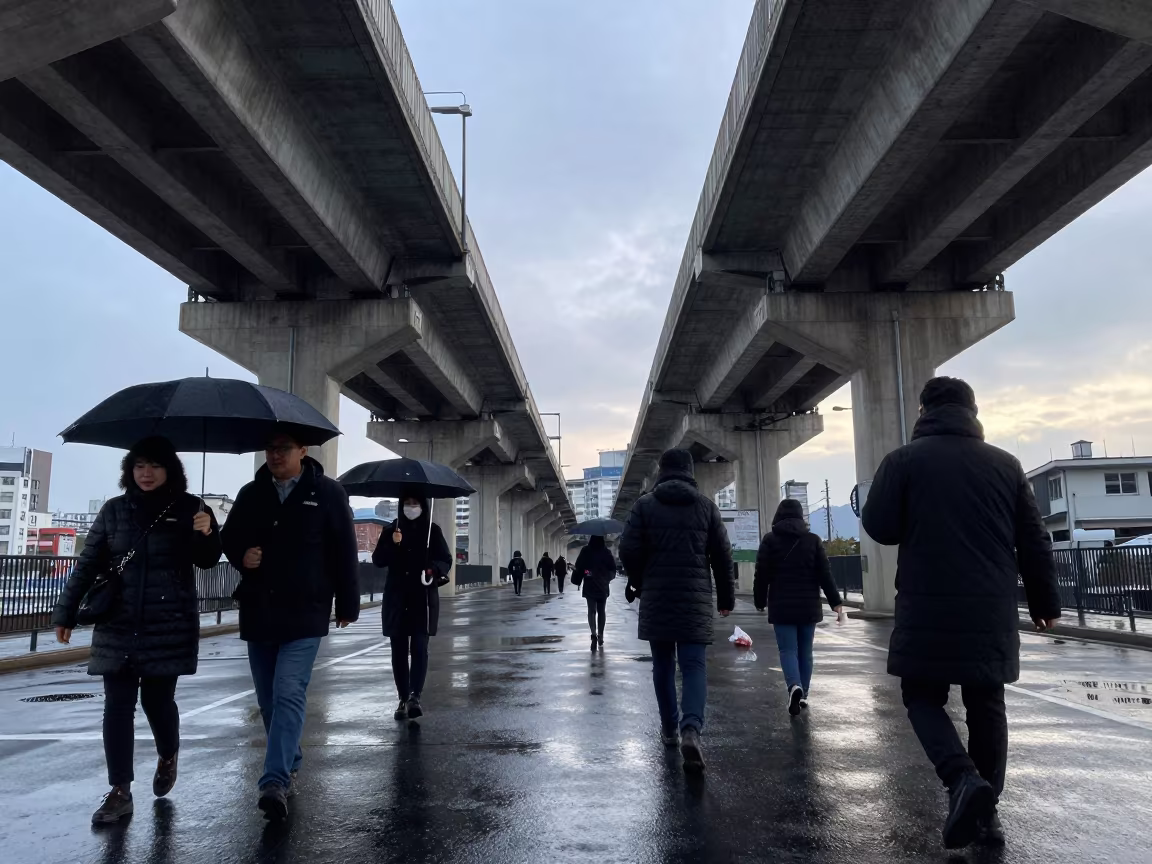 Cold dawn commuters beneath Keelung rail overpass in under an elevated train line in Keelung