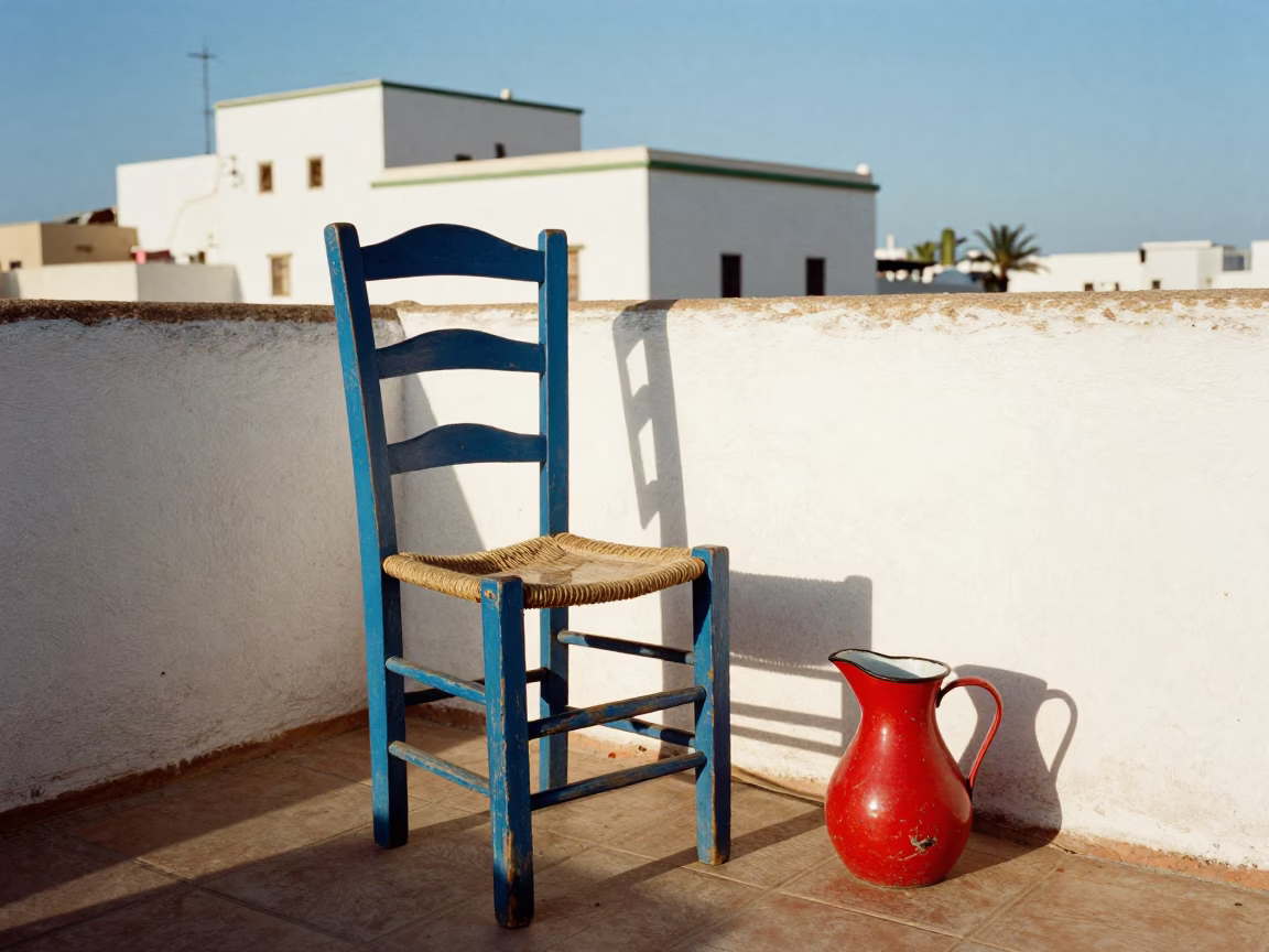 Colorful Wooden Chair and Enamel Pitcher on Essaouira Terrace Early Afternoon in in Essaouira, Morocco