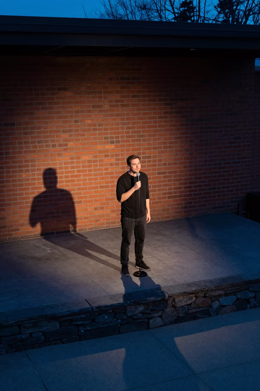 Comedian Lit by Blue Hour Spot on Brick Wall in on a stone ledge in Duluth