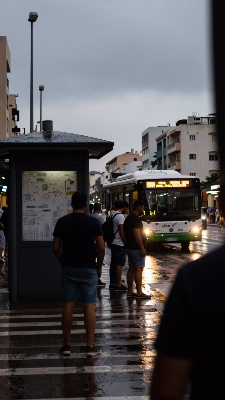 Commuters Jostle at Crosswalk as Bus Departs Casablanca in by a rain-darkened kiosk in Casablanca
