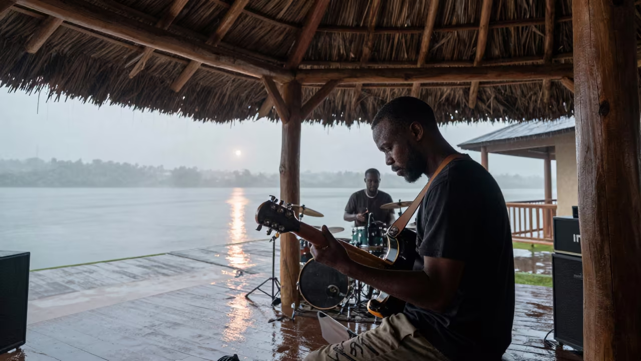 Congolese Soukous Guitarist Under Thatch in Monsoon in in a rehearsal room in Kingston