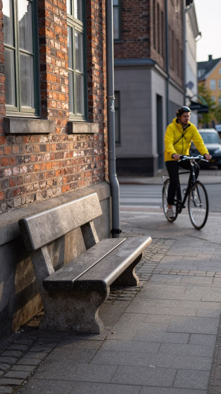 Copenhagen late afternoon street scene with stone bench and casual urban life in in Copenhagen, Denmark