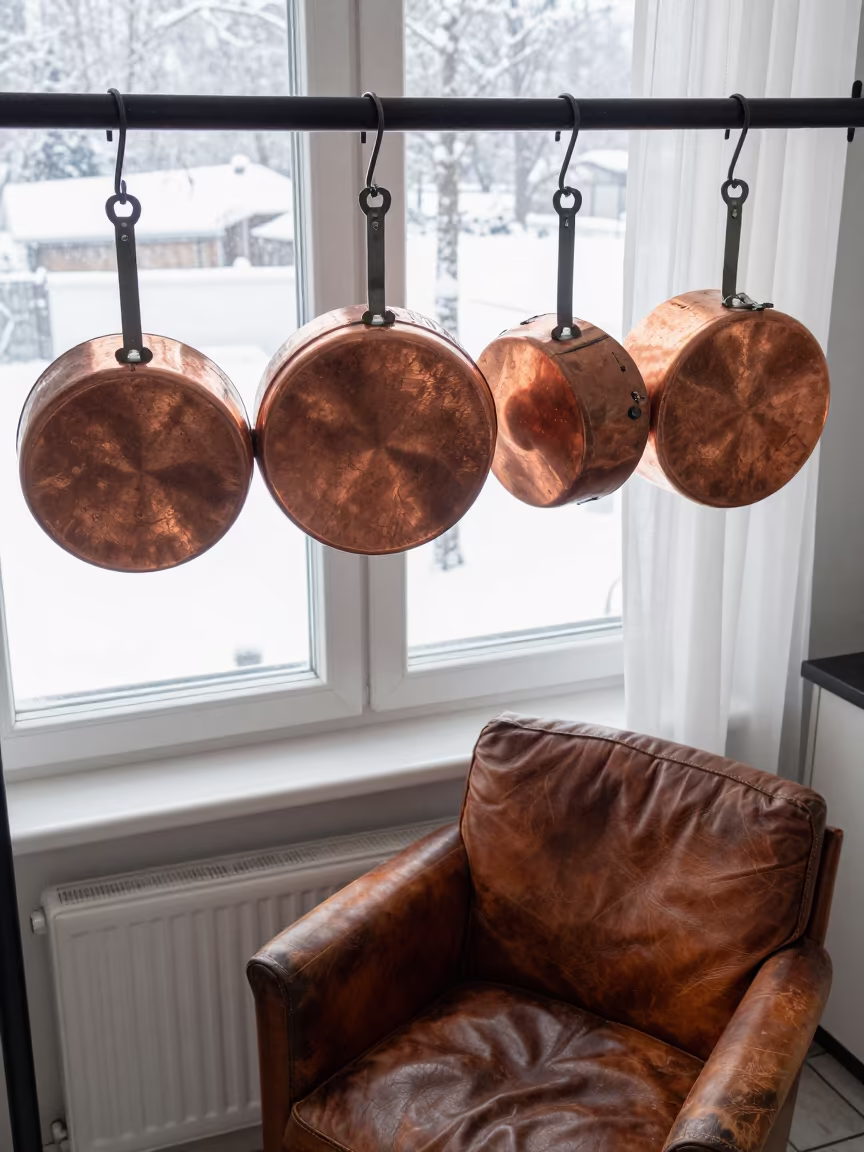 Copper Pots Hanging Over Winter Kitchen Dawn in on a worn leather armchair near Chorzów
