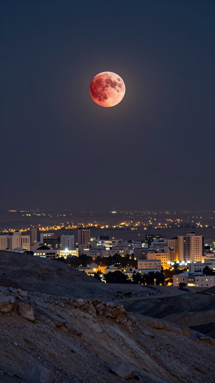 Copper Red Moon Over Oman Cityscape in from a frost-hushed ridgeline in Oman