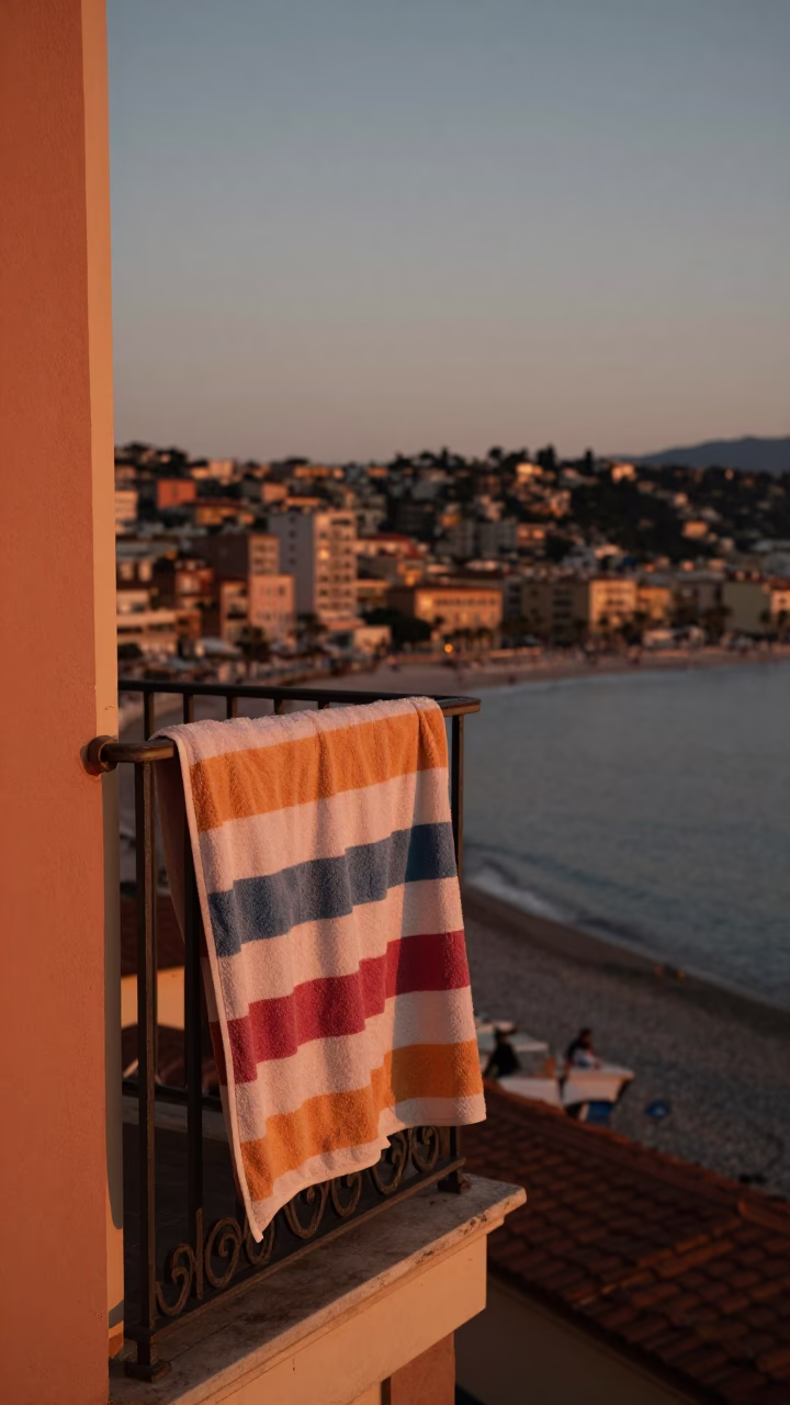 Copper-toned dusk in Nice France with striped towel on balcony overlooking Mediterranean in in Nice, France