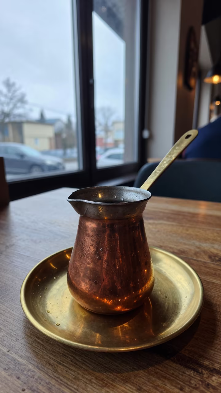 Copper Turkish Pot on Brass Plate in on a small cafe table by a window in Chengdu