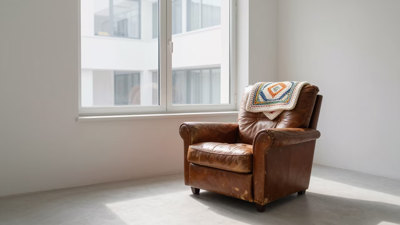 Crochet Blanket on Leather Chair with Indoor Window View in on a worn leather armchair in Salalah