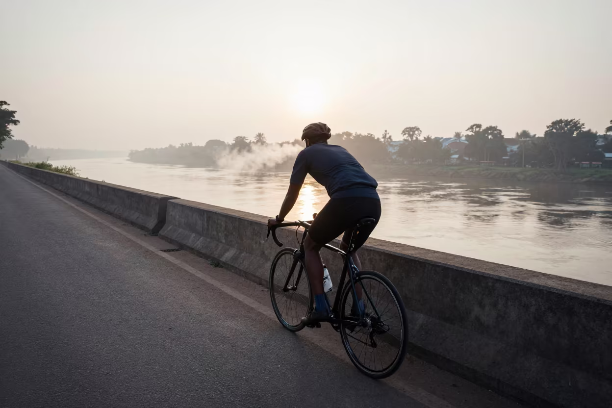 Cyclist Breathing Mist Before Dawn by Riverbank in by a riverbank near Harare