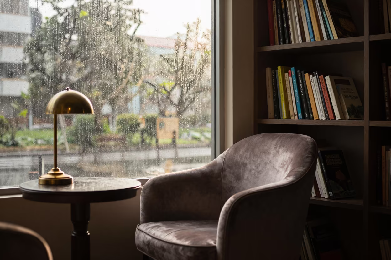 Dawn Light Dust Velvet Chair Bookshelf Thu Duc in beside a rain-streaked window in Thủ Đức