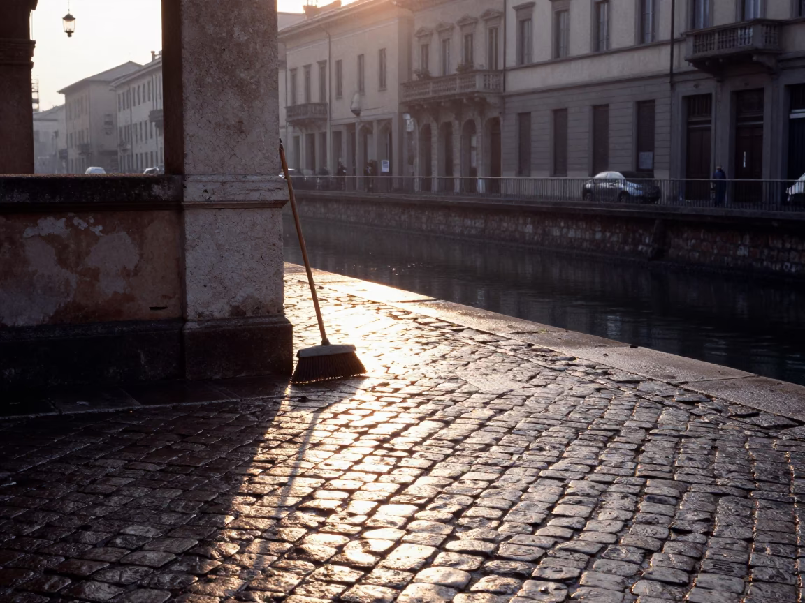 Dawn Light on Milan Cobblestones with Broom and Coffee Tin Near Navigli Canal in in Milan, Italy