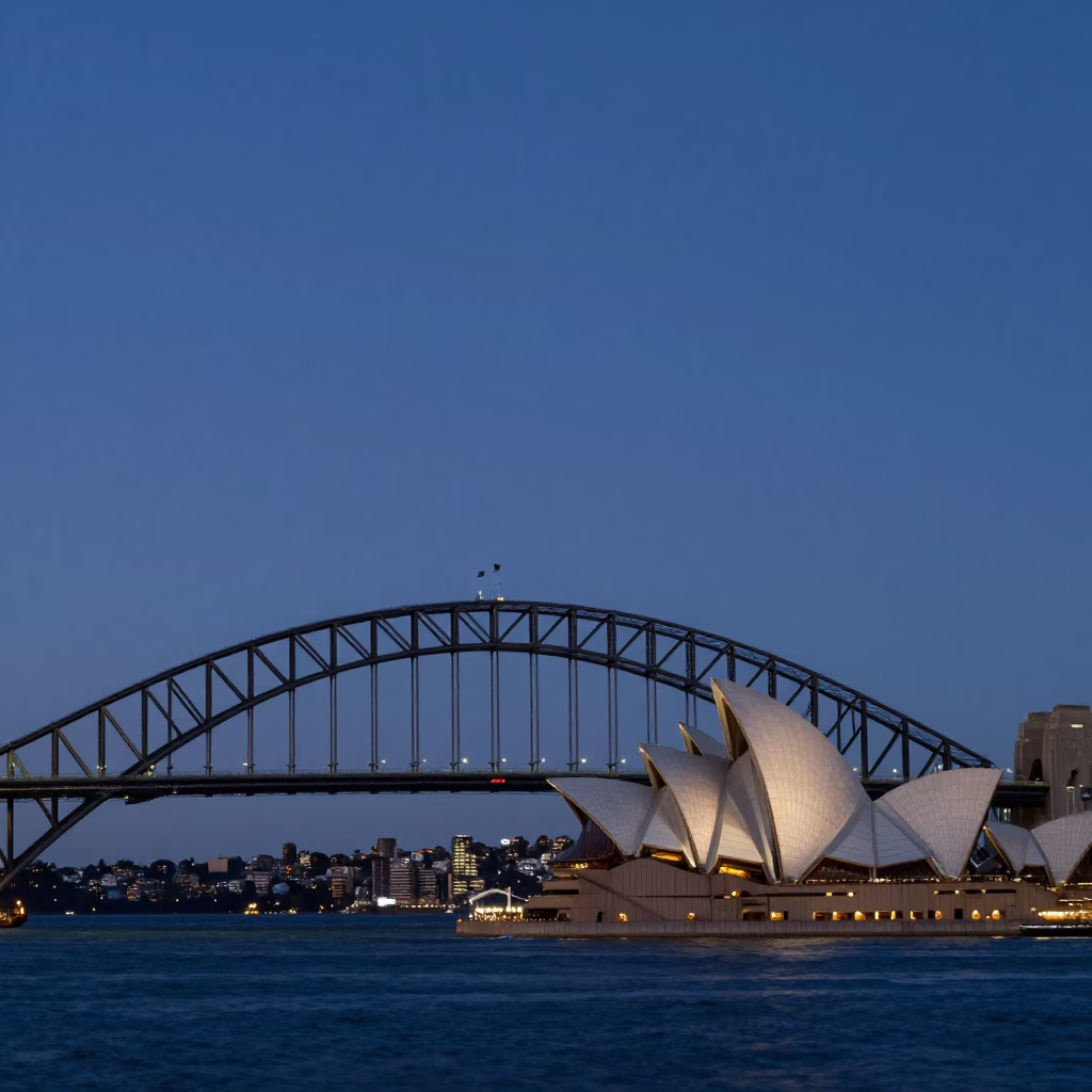 Dawn light on Sydney Harbour Bridge and Opera House with distant zeppelin airship silhouette in in Sydney, New South Wales, Australia