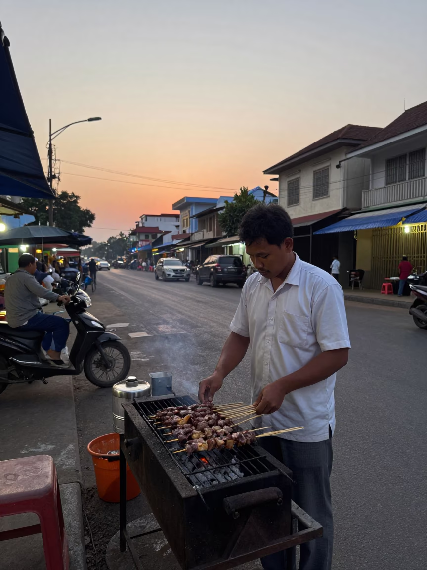 Dawn Street Food Vendor in Phnom Penh Cambodia with Charcoal Grill and Metal Chair in in Phnom Penh, Cambodia