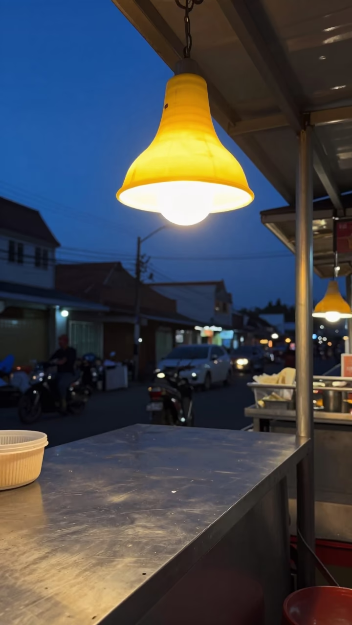 Denpasar Indonesia street food stall illuminated by table lamps during indigo twilight hours in in Denpasar, Indonesia