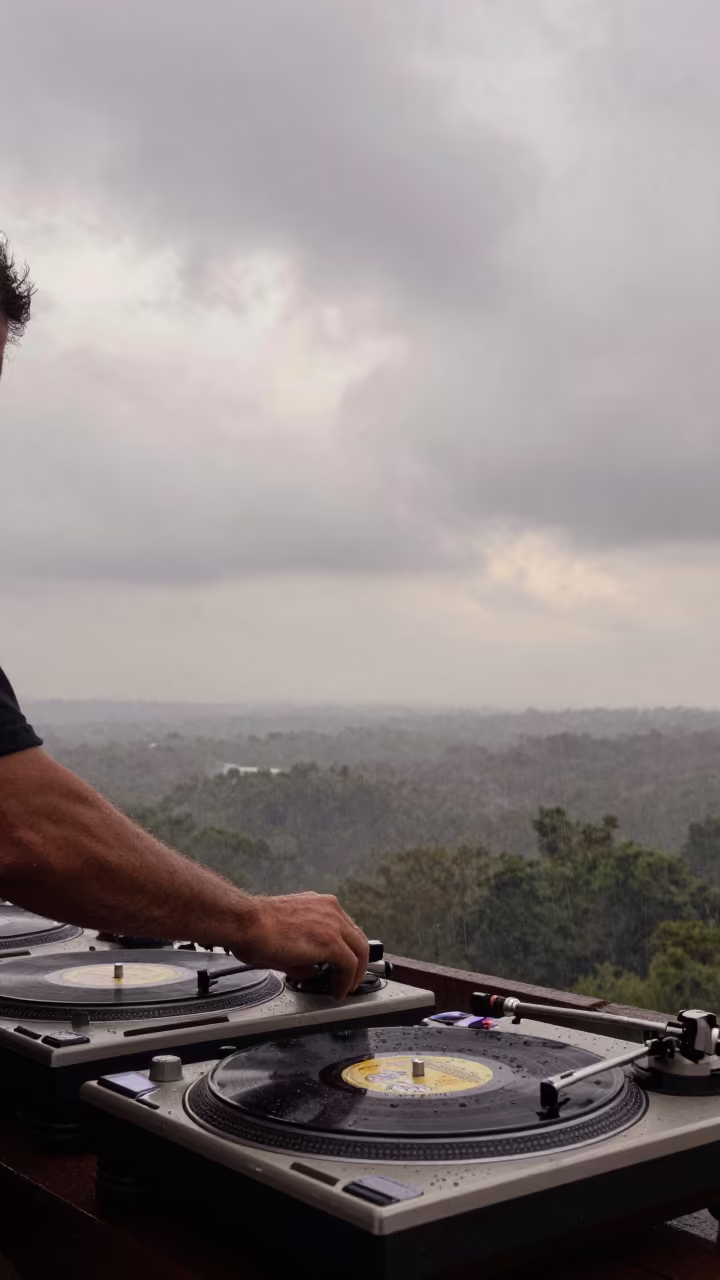 DJ Spinning Vinyl Under Arkansas Clouds at Dawn in beneath fast-moving cloud bands in Arkansas