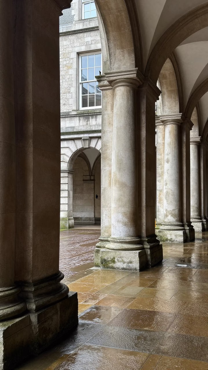 Dublin Ireland noon light on wet university arcade columns and skittering leaves in in Dublin, Ireland