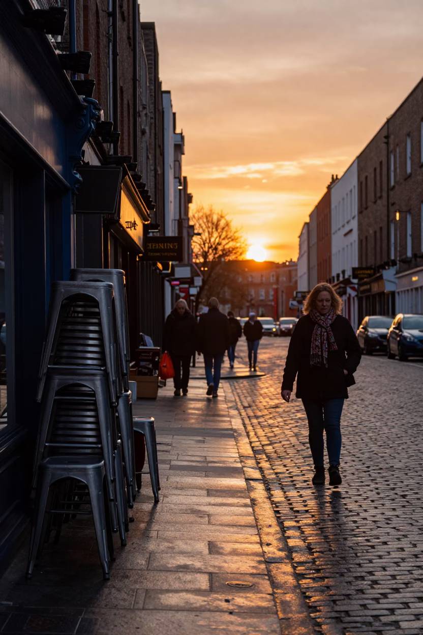 Dublin Sunset Street Scene with Scarf and Metal Stools Outside Historic Building in in Dublin, Ireland