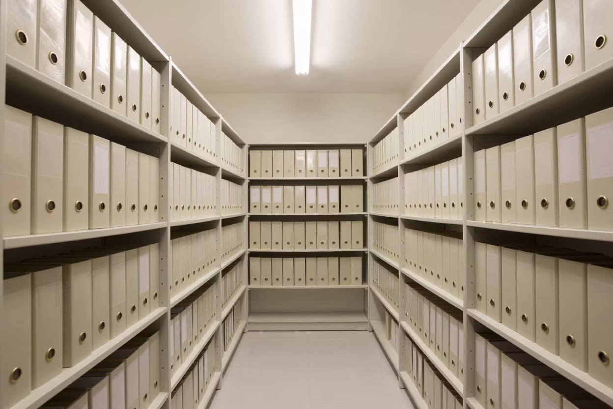 Dusty Lease Binder Shelf in Berlin Office in in an operations center under monitor glow in Berlin