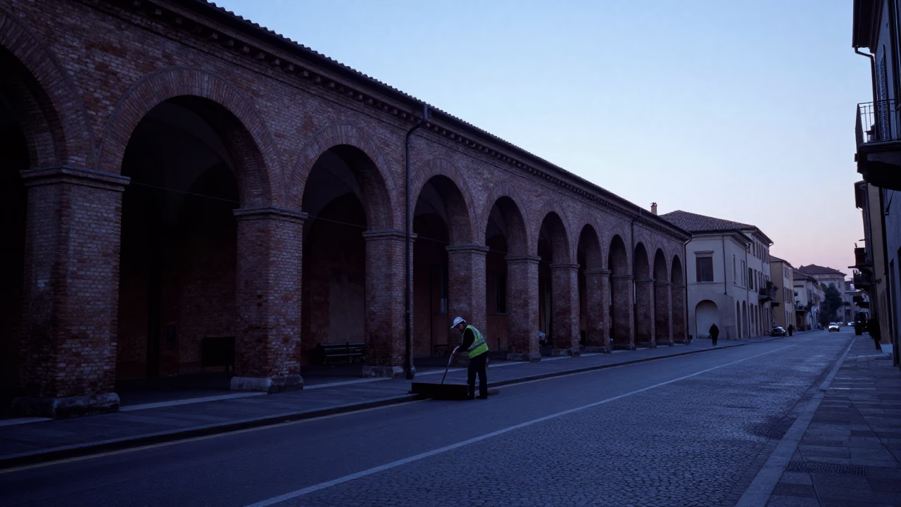 Early Morning Bologna Street Cleaning Before Sunrise with Hand Broom and Cobblestones in in Bologna, Italy
