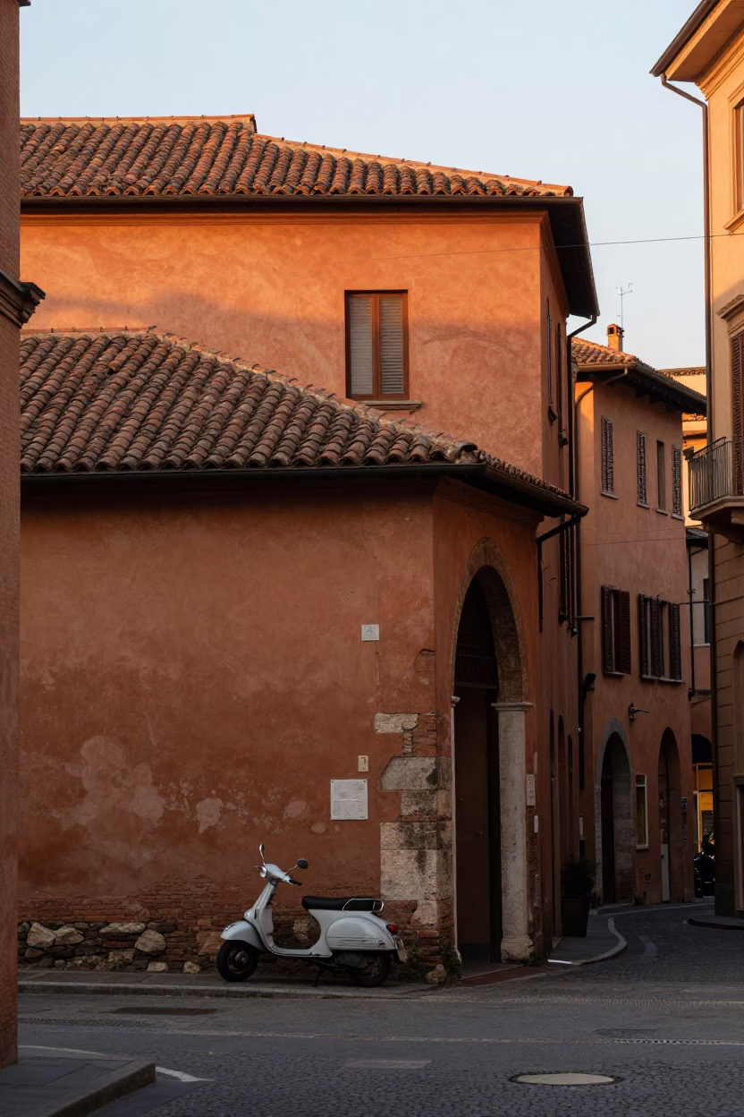 Early morning light illuminates historic Bologna street corner with parked motorcycle and traditional architecture in in Bologna, Italy