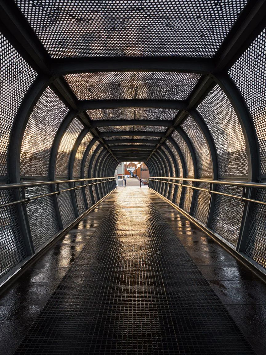 Early Morning Light on Bristol Pedestrian Overpass with Perforated Metal and Wet Footsteps in in Bristol, United Kingdom
