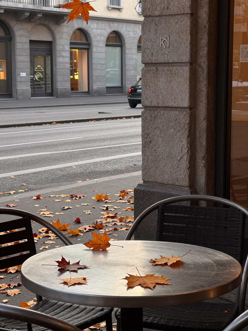 Early Morning Milan Street Scene with Autumn Maple Leaves and Brushed Steel Tabletop in in Milan, Italy