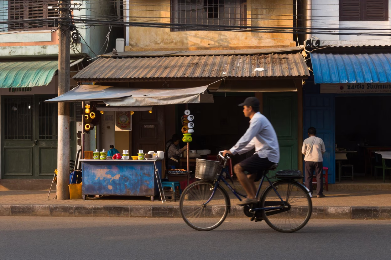 Early Morning Phnom Penh Street Scene with Cyclist and Tea Stains in in Phnom Penh, Cambodia