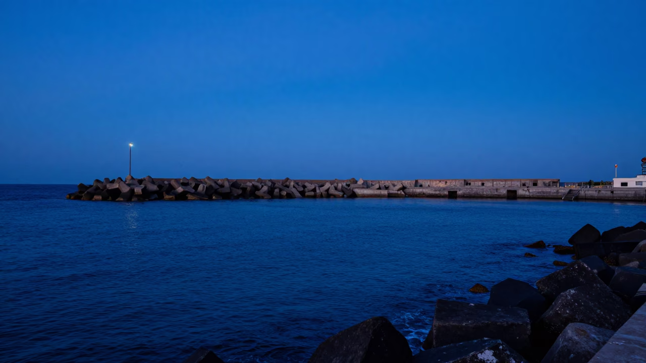 Evening Harbor Scene in Dakar Senegal with Blue Hour Sky and Breakwater in in Dakar, Senegal