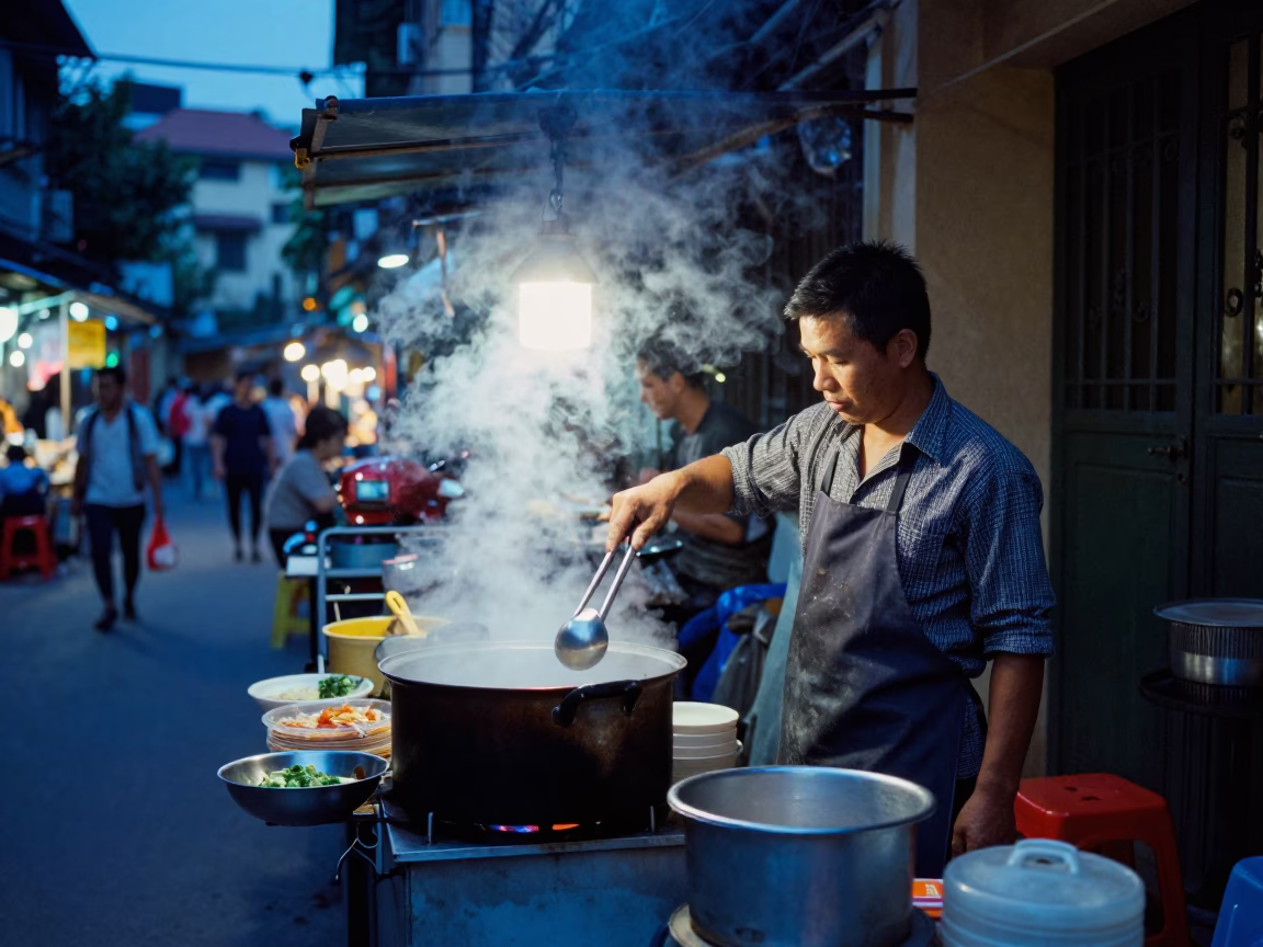 Evening Street Food Vendor in Hanoi Vietnam with Steam and Kitchen Tongs in in Hanoi, Vietnam