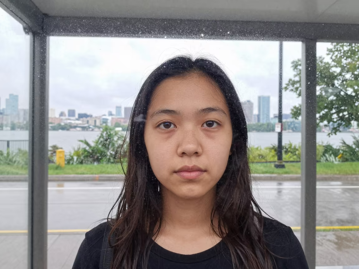 Face Behind Rain Streaks at Toronto Bus Shelter in near a riverside landing in Toronto