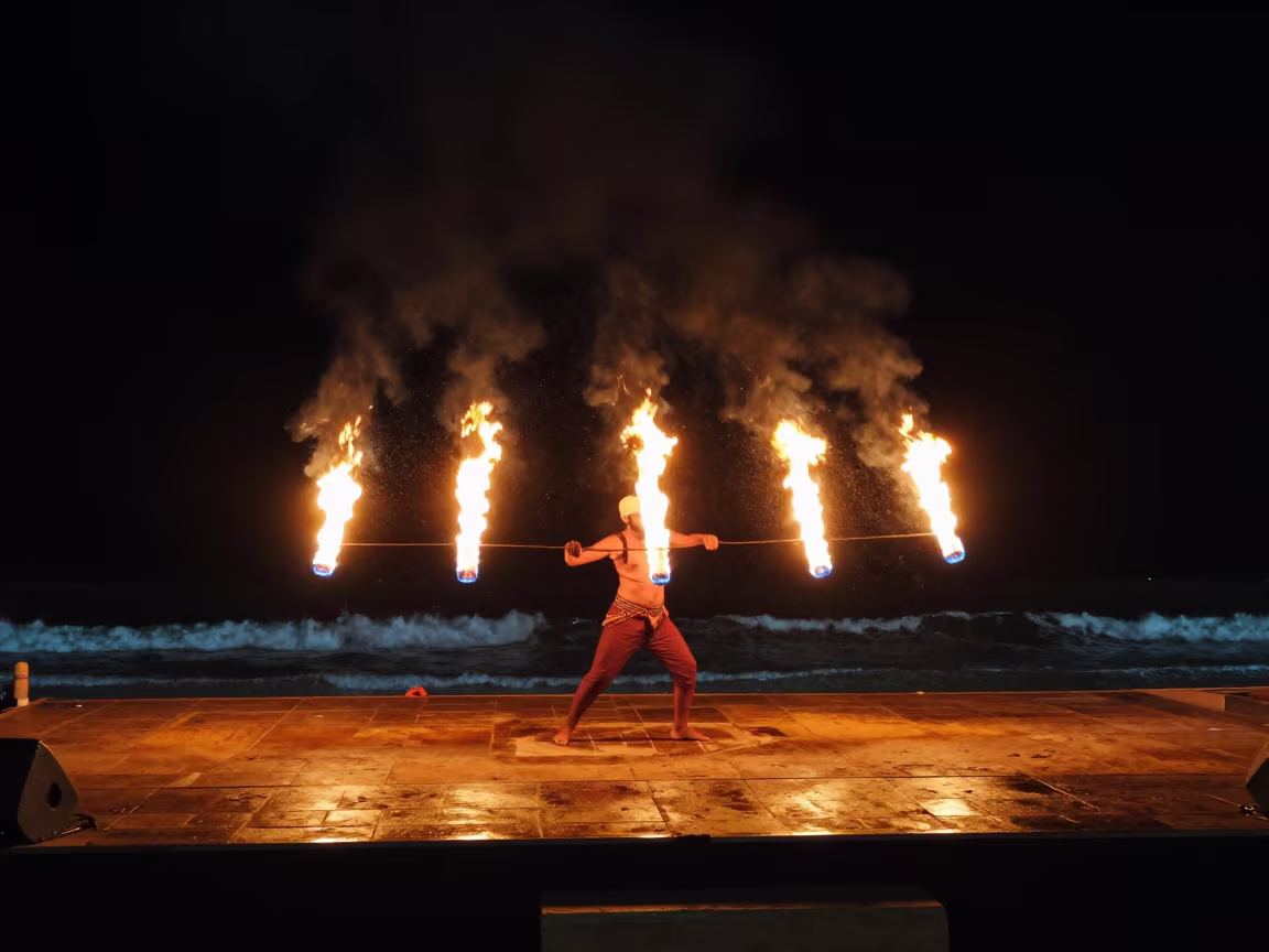 Fire Dance Traced in Orange Arcs Against Black Surf in on a festival main stage in Salalah