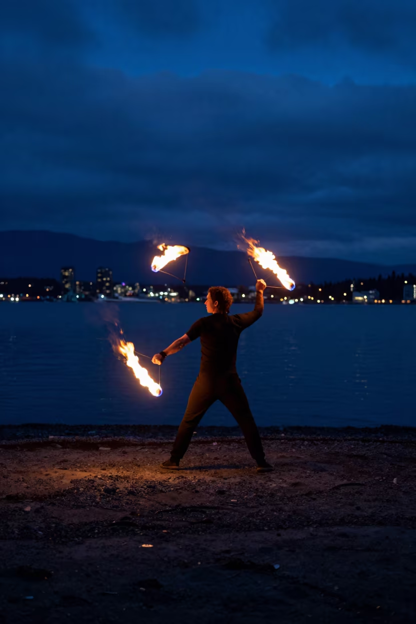Fire Dancer Spinning Poi Trails on Dark Vancouver Beach in in Granville Island, Vancouver