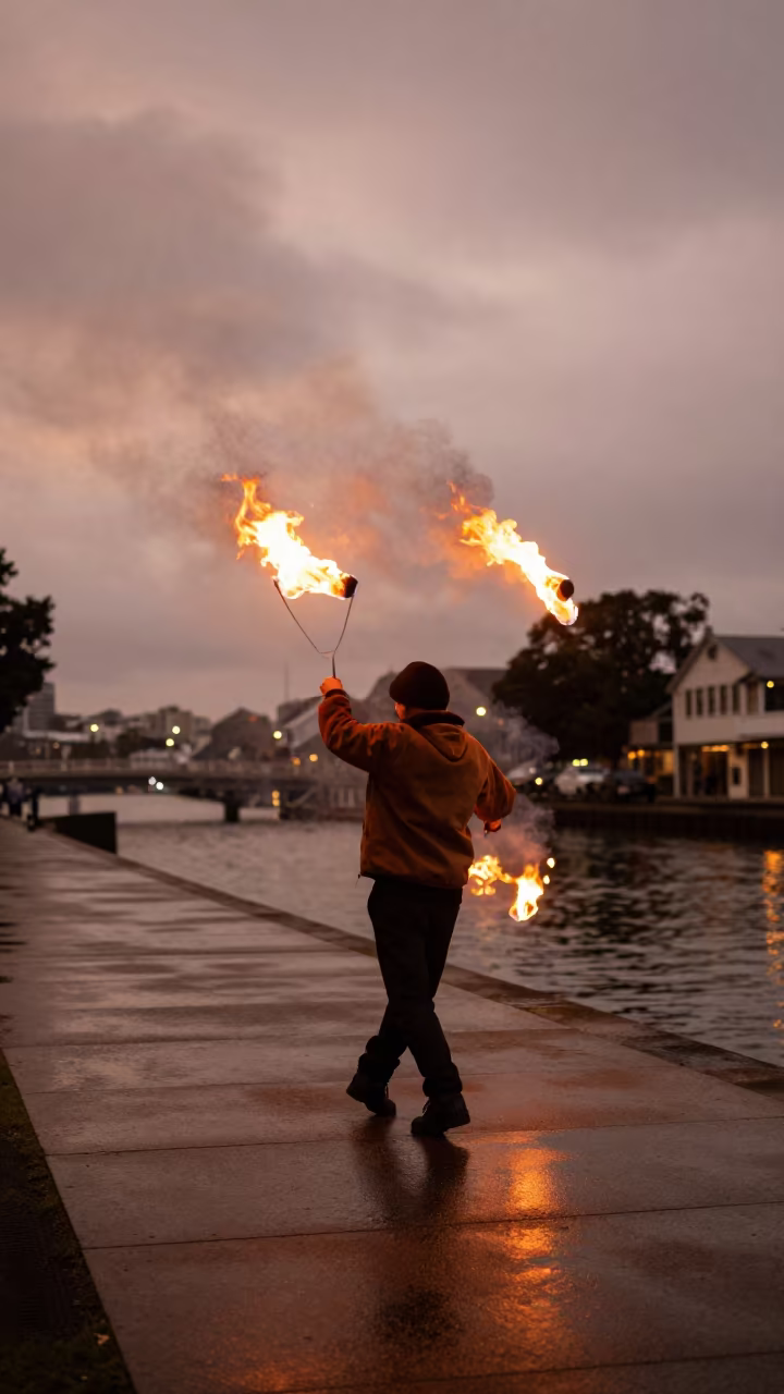 Fire Dancer Spinning Poi on Auckland Beach in beside a canal in Auckland