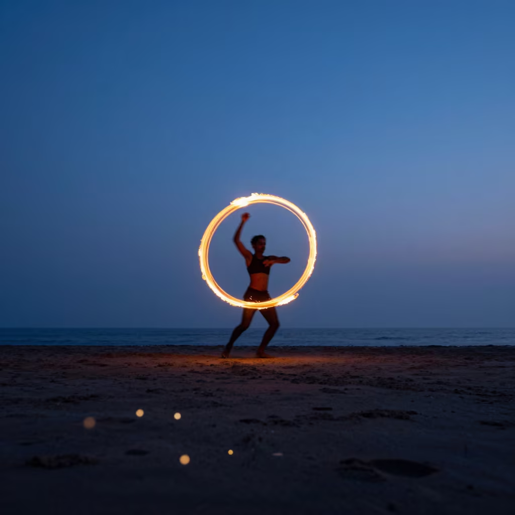 Fire Dancer Spinning Poi Trails on Colaba Beach in at a harbor edge in Colaba, Mumbai