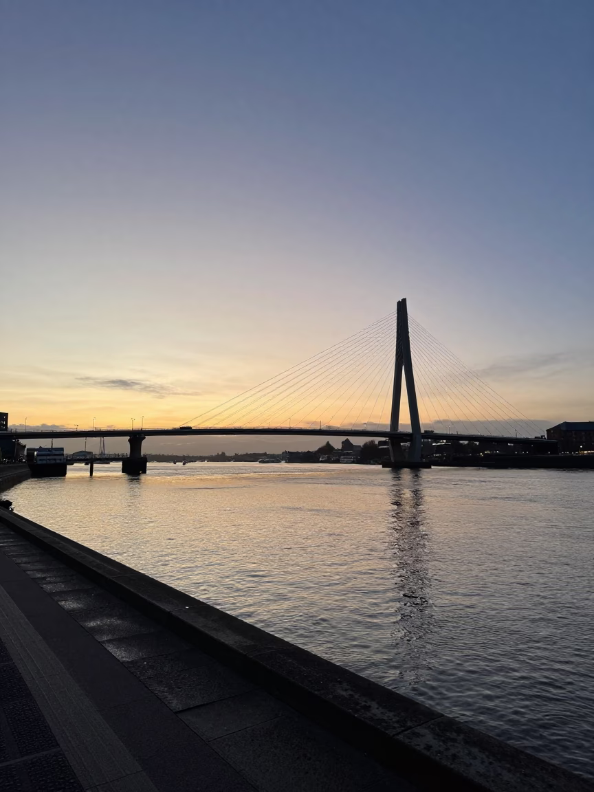 First Light Dawn over Bristol Harbourside Cable Stayed Bridge Illuminated Against Dark Water in in Bristol, United Kingdom