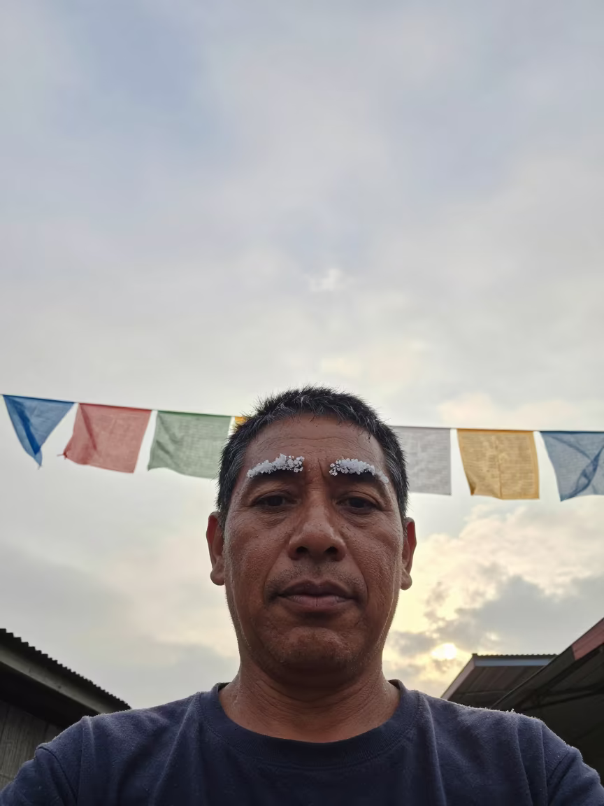 Fishmonger Portrait with Salt Eyebrows in beneath a line of prayer flags near Los Angeles