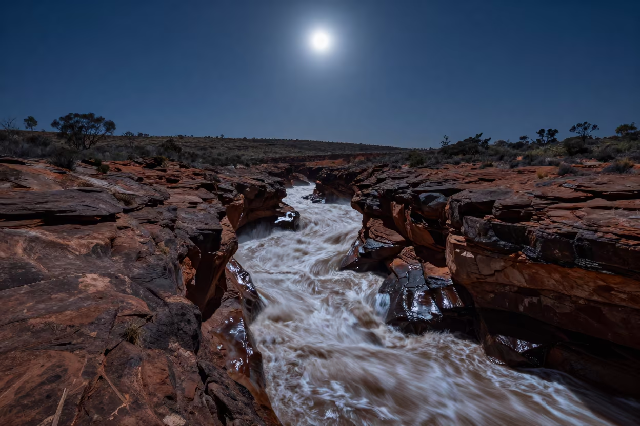 Flash Flood Carves Canyon Under Moonlit Night Sky in from a ridge above layered foothills in Australia