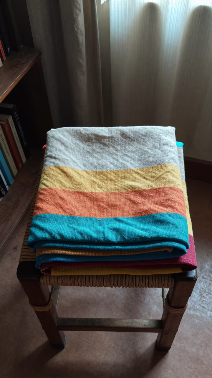 Folded Blanket on Woven Stool in Makurdi Library in on a dusty library table in Makurdi